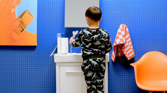 a kid brushes his teeth